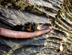 rusty curved bar on decayed wood