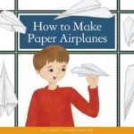 White boy in red shirt holds a paper airplane
