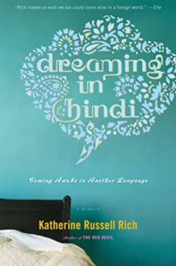 dreaming in hindi cover with a turquoise background with a bed in the bottom left corner
