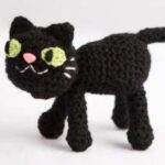 Black crocheted cat with green eyes