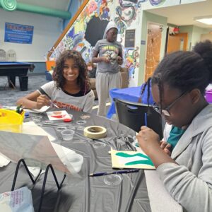 Two teen girls painting small canvases