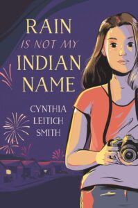 First Nations teen girl with camera and fireworks in sky