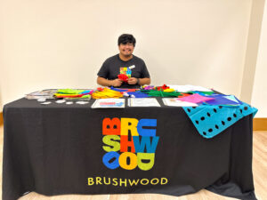 Brushwood Center staff member sitting at a table during library's community ofrenda.