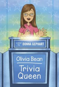 Girl with brown hair, green glasses and pink shirt stares out while speaking from a blue podium