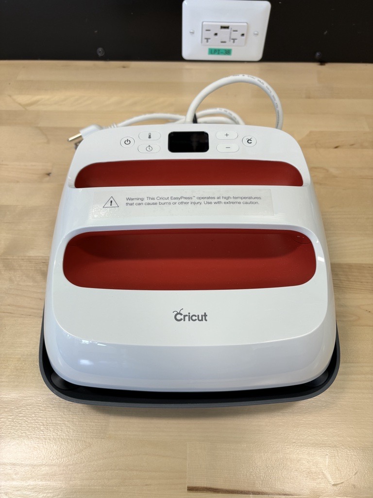 Cricut Easy Press. A heat transfer tool that works like a giant iron for designs to be placed on fabric.