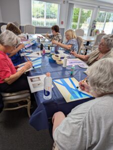 Library program at a senior living facility where residents learn how to paint birch trees.