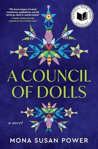 The cover of “A Council of Dolls” by Mona Susan Power. Native beadwork frames the title and lays in front of a dark blue background.