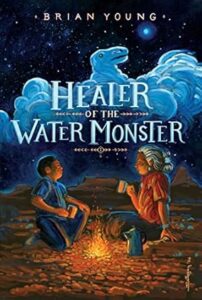 The cover of “Healer of the Water Monster” by Brian Young. A young Native American boy sits with an elderly Native American man, outside at night by a fire, drinking out of hot cups. A night sky lit with stars shines overhead and a rolling cloud is shaped to be reminiscent of a “water monster”.  