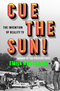 An image of the cover “Cue the Sun!” by Emily Nussbaum. A vintage, black and white image of a group of people who are filming a movie seen out by a pool takes up the cover. One woman lays on a pool chair. Another woman sits on the ground on her knees. A man sits adjacent to the women on another pool chair. A man stands back with a large camera, filming the scene.  