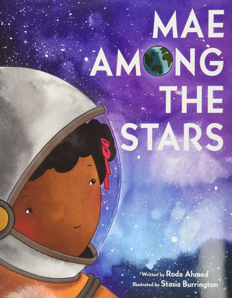An image of the book cover for “Mae Among the Stars” by Roda Ahmed. A young black girl wearing an astronaut helmet glances up at a galaxy sky.