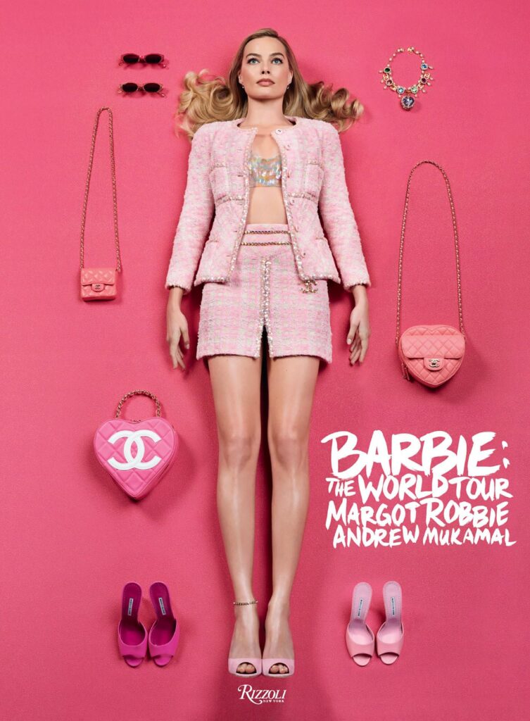 Cover of Barbie: The World Tour by Margot Robbie and Andrew Mukamal. A woman in a pink tweed outfit lies on a pink background, surrounded by matching pink accessories (bags, shoes, and jewelry). The title and authors’ names appear in bold white text at the bottom right, with the Rizzoli logo below.