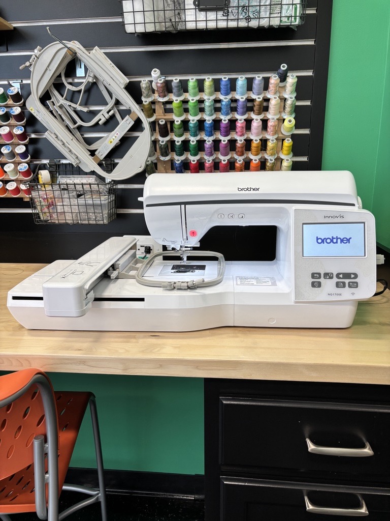 Large white machine with embroidery hoop on top.