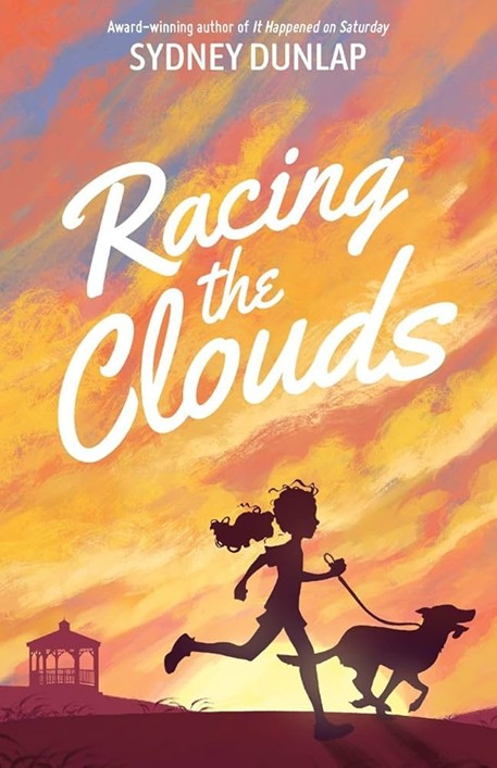 Silhouette of young girl running with her dog with the sunset behind her.
